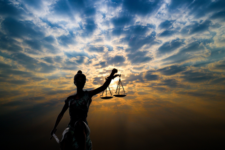 Lady justice statue against backdrop of a cloudy sunset