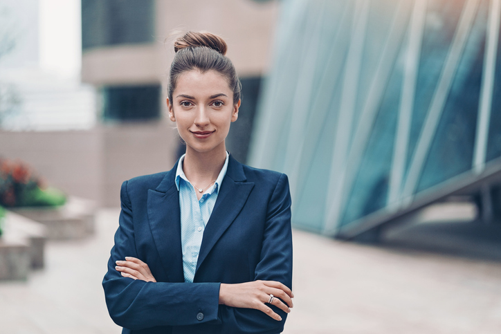 Young professional female standing outside a glass office building