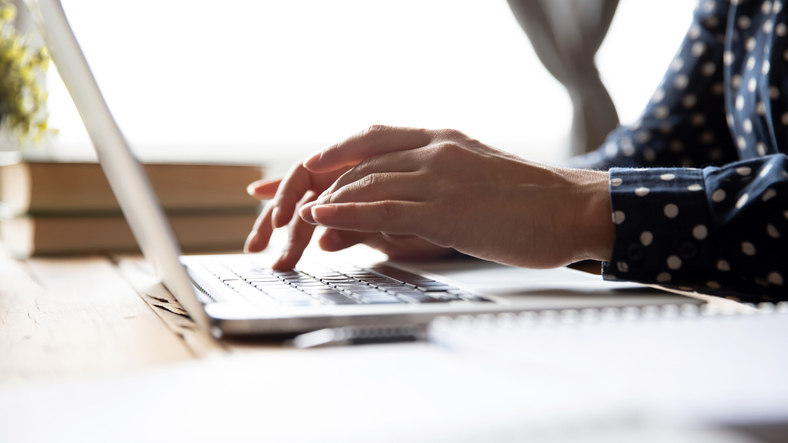 Close up of hands typing on a laptop